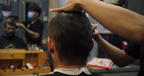 A Professional Hairdresser Makes a Hair and Beard Strip to the Client