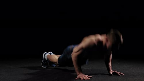 Young Pumped Man Trains in the Arena Doing a Back Flip and Doing Push Ups