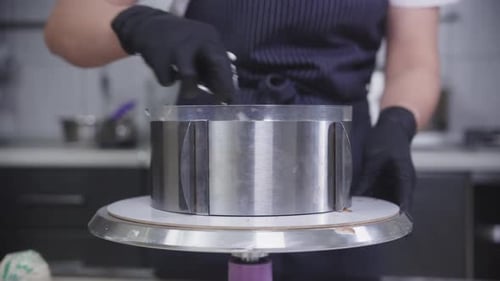 Confectionery a Woman Smears Vanilla Cream Onto the Bisquit in the Form