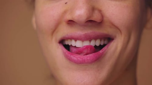 Portrait macro rapproché d'une femme afro-américaine se léchant les lèvres avec la langue et se mordant le bas