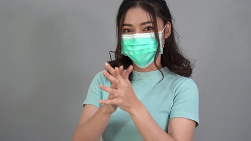 woman in a medical mask(surgical mask) using alcohol gel to washing hand, coronavirus protection