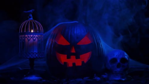 Scary laughing pumpkin and an old skull over the frightening gothic background.