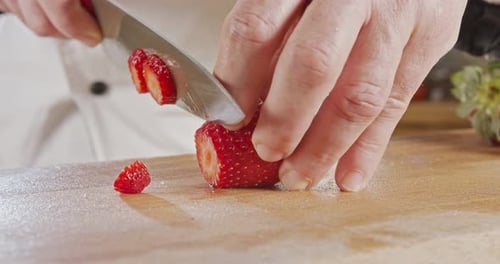 Close up of a chef knife slicing a Strawberry