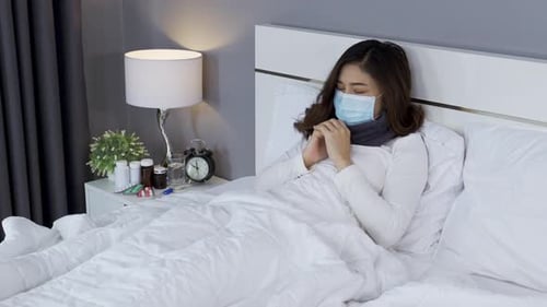 sick woman in medical mask feeling cold and coughing and suffering from virus disease