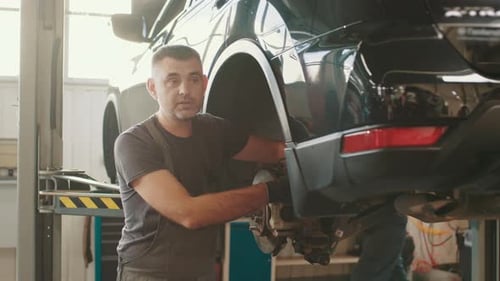 Car Mechanic Replacing Car Wheel Brake Shoes of Lifted Automobile Ac Repair