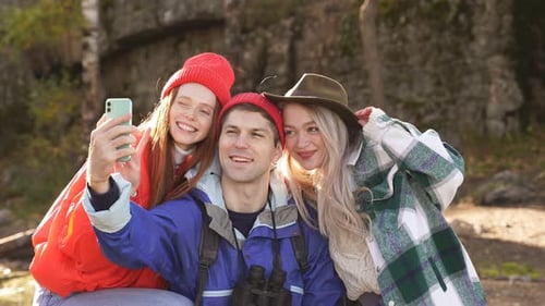 Three Caucasian Friends Enjoy Spending Time in Forest After Climbing Mountains.