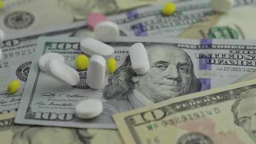 Píldoras cayendo en billetes de dólar, medicamentos caros, negocios farmacéuticos