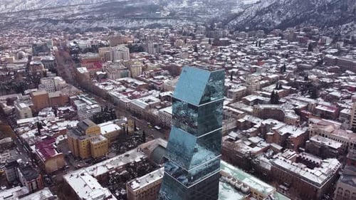 Glass skyscraper in the snowy city