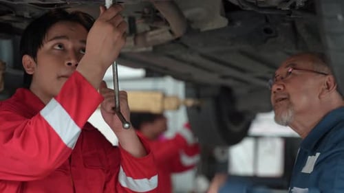 technician man car mechanic working in automotive garage to fix repair suspension auto car