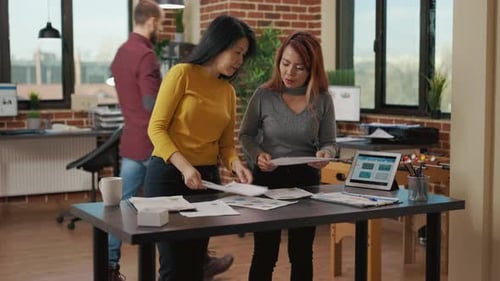 Frauenteam analysiert Statistiken auf Papieren und Laptop