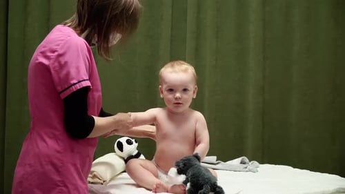 The masseuse gives a massage of shoulder to baby (boy) 03