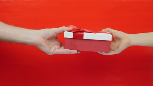 Woman gives gift box for man for Valentines Day, Christmas or Birthday