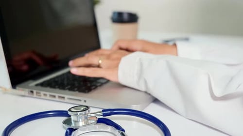 La doctora escribe la información sobre la receta del paciente del papeleo, el formulario de historial