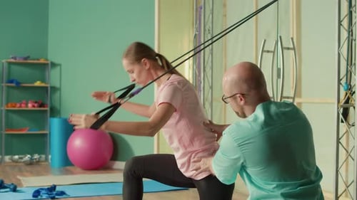 The Personal Trainer Helps the Athlete to Perform Exercises in the Gym