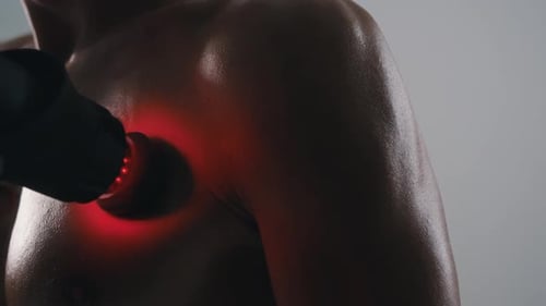 Muscled Man Uses Body Massager