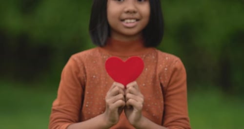 Girl holding red paper hearts