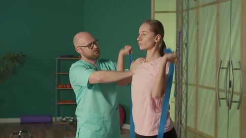 A Physiotherapist Helps a Girl Do Exercises to Relieve Her Back Pain