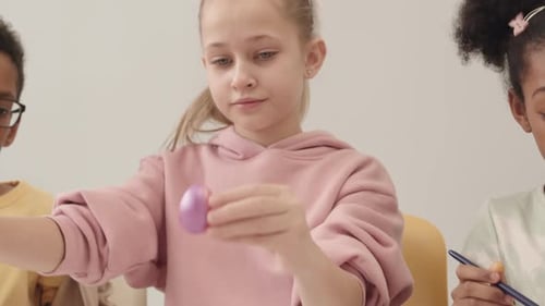 Portrait of Girl Coloring Easter Eggs with Friends