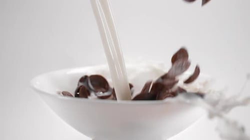 Chocolate Corn Flakes and Milk Are Falling To the White Bowl in Slow Motion, Cocoa Cereal Breakfast