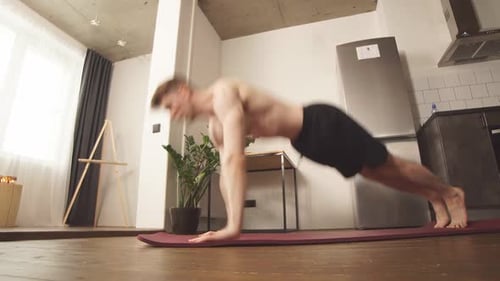 Athletic Fit Man Making Side Stand on Mat in Domestic Room