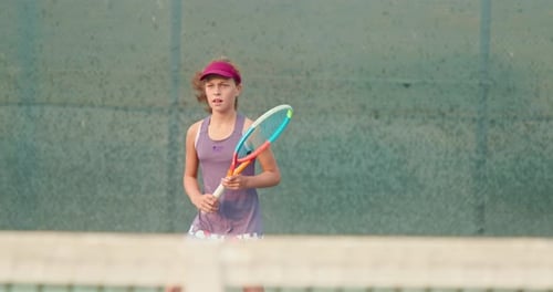 Athletic Girl Playing Tennis on Court. Active Teenager Is Hitting Ball By Racket