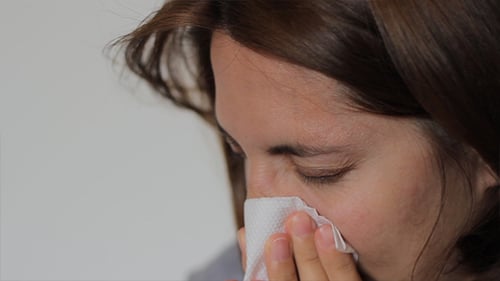 La mujer se sopla la nariz