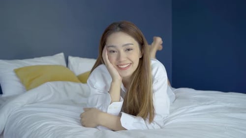 Portrait of beautiful attractive young woman smile and look at camera in cozy bedroom at home
