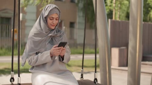 Muslim Woman with Smartphone Outdoors