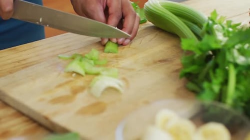 Fit african american man cooking, preparing healthy green smoothie