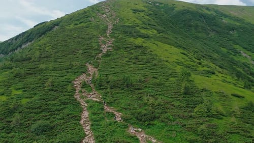 Aerial View of Young People Walking Along a Mountain Trail to the Top of the Mountain
