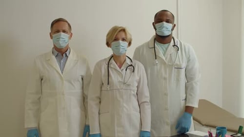 Profissionais de saúde multiculturais diversificados e confiantes com braços cruzados posando na clínica médica