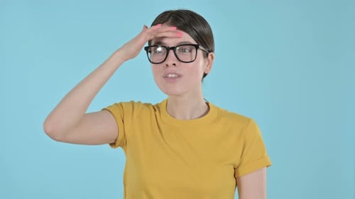 Mujer joven inquisitiva que busca algo sobre fondo púrpura