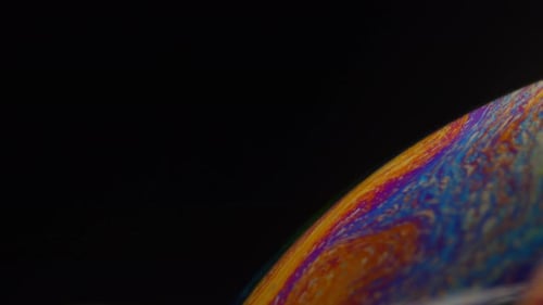 Panning Macro Abstract Shot of Colorful Rainbow Colors on Surface of Bubble