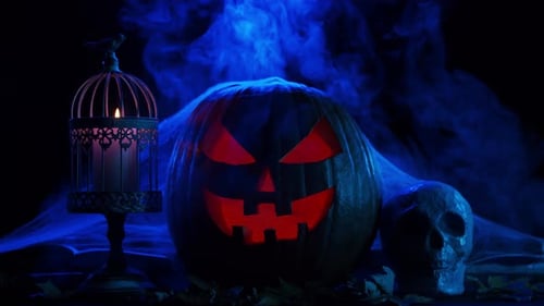 Scary laughing pumpkin and an old skull over the frightening gothic background.