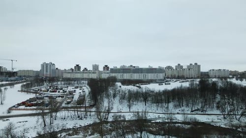 Suburb of a big city. City Park. City highway with busy traffic. Winter cityscape. Aerial photograph
