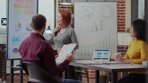 Multi Ethnic Team Attending Briefing Presentation in Boardroom