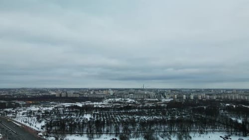 Suburb of a big city. City Park. City highway with busy traffic. Winter cityscape. Aerial photograph