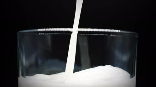 Macro Of Fresh Milk Poured In Crystal Clear Glass. Close Up