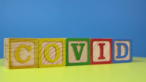 Wooden block of alphabet COVID rotating