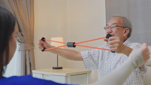 Asian Disabled senior man doing physiotherapist using resistance stretch band exercise for health.