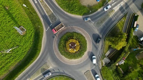 Top View Of Vehicles Passing By The Roundabout In Lubawa, Poland - orbiting drone shot, slow motion