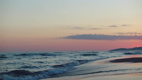 Sea waves washing beach after sunset