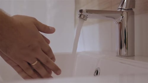 Man Washing Soapy Hands in Bathroom