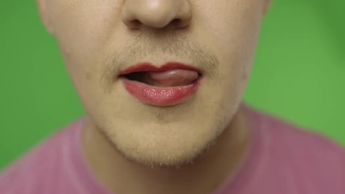 Un homme barbu aux lèvres peintes les lèche sexuellement. Communauté LGBT. Transsexuel