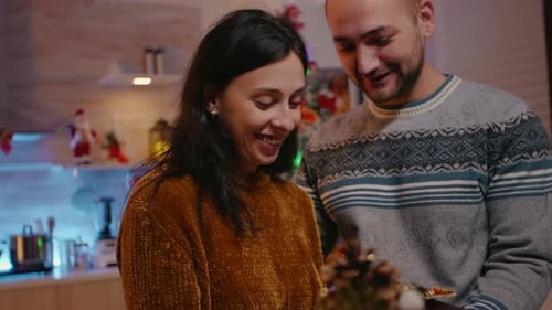 Woman Receiving Present From Man on Christmas Day