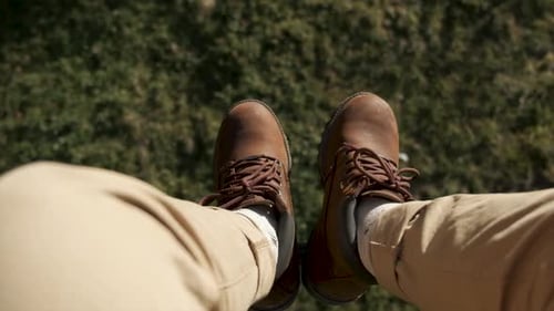 Flying Over the Beautiful Forest Trees. Aerial Camera Shot and Human Legs with Blue Sneakers in