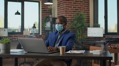 Company Employee Analyzing Financial Statistics on Laptop