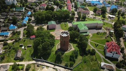 Flight Over A Provincial Town. An Ancient Tower Among The Multi Colored Roofs Of Houses