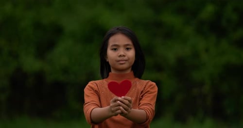 Girl holding red paper hearts