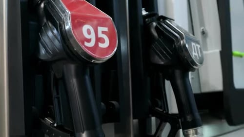 Die Hand hält die Füllpistole an der Tankstelle